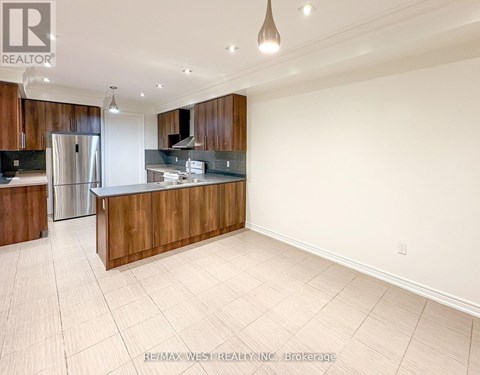 A spacious kitchen with wooden cabinets and a refrigerator.