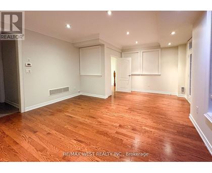 A room with wooden flooring and white walls.
