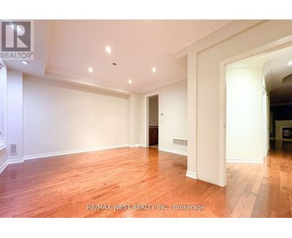 A large, empty room with wooden floors and white walls.