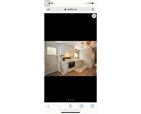 A kitchen with white cabinets and a window.