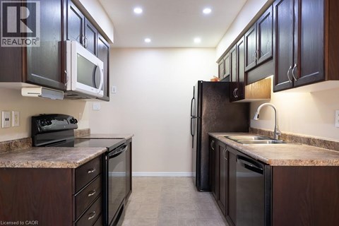 A kitchen with brown cabinets and a granite counter top.
