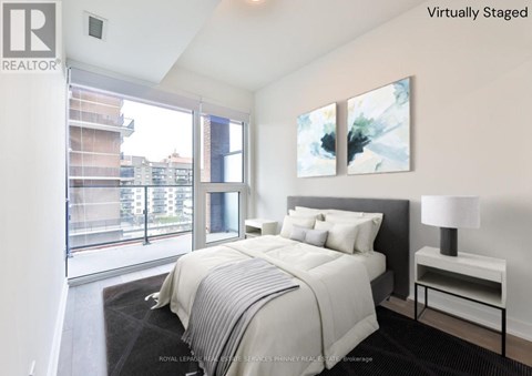 A bedroom with a large bed and a painting on the wall.