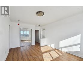 A room with wooden floors and white walls, with a window letting in natural light.