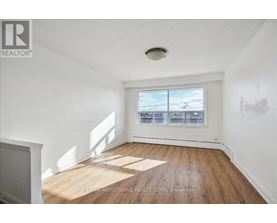 A room with a window showing a view of a parking lot.