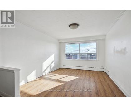 A room with a window showing a view of a parking lot.