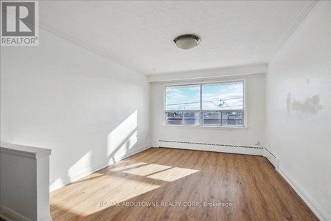 A room with a window showing a view of a parking lot.