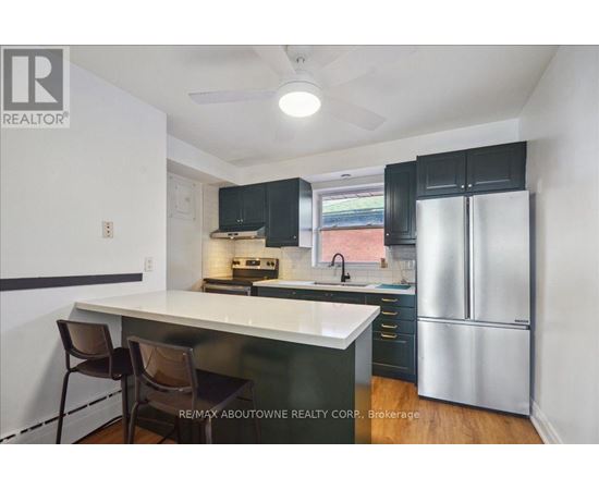 A kitchen with a white counter top and black cabinets.