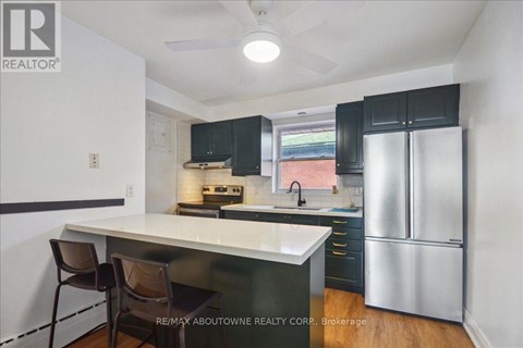 A kitchen with a white counter top and black cabinets.