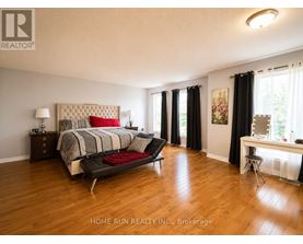 A bedroom with a large bed and a desk with a chair.