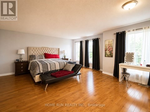 A bedroom with a large bed and a desk with a chair.
