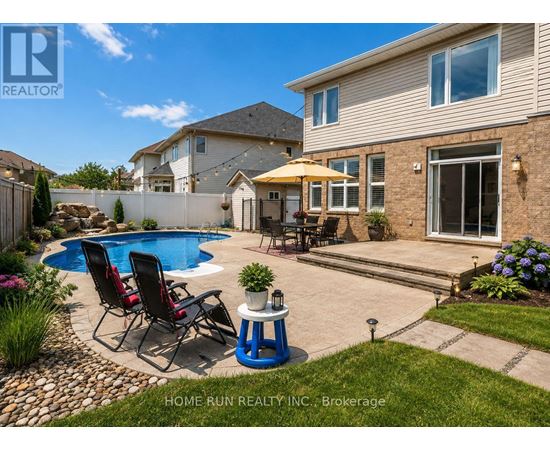 A real estate photo of a house with a pool and a patio.