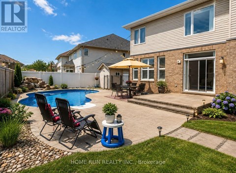 A real estate photo of a house with a pool and a patio.