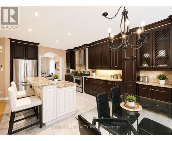 A modern kitchen with dark brown cabinets and a marble island.