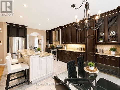 A modern kitchen with dark brown cabinets and a marble island.