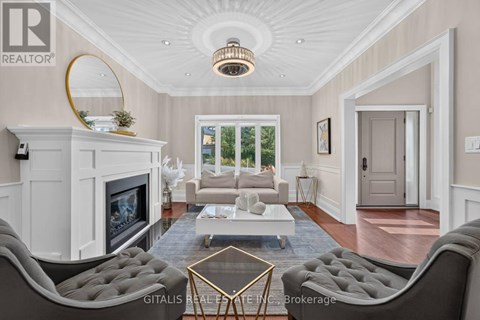 A living room with a grey sofa and a white fireplace.