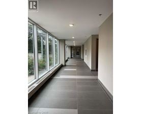 A long hallway with a tiled floor and windows on one side.