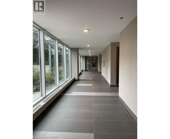 A long hallway with a tiled floor and windows on one side.
