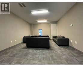 A spacious room with a grey carpet and two black sofas.