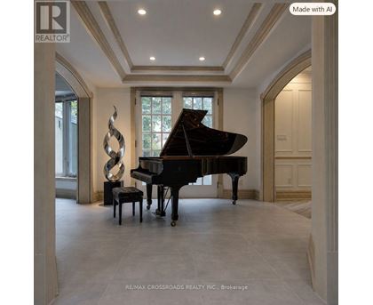 A grand piano sits in a spacious room with a large sculpture beside it.