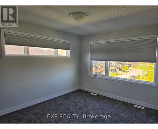 A room with a window showing a view of a residential area.