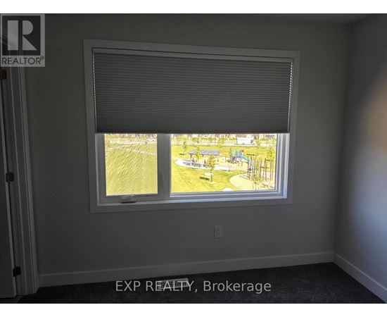 A room with a window showing a view of a park.