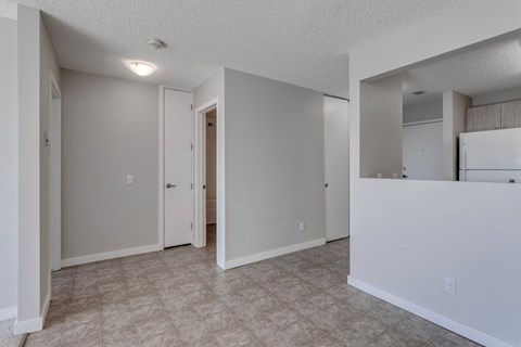 A spacious room with a doorway leading to another room.