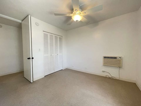 A room with a ceiling fan and a white door.