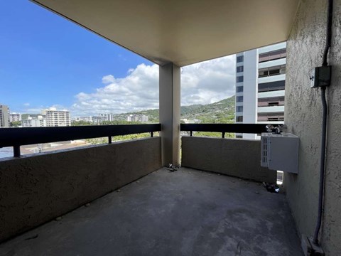 A balcony with a concrete floor and a view of the city.