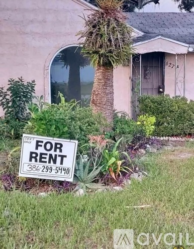 A house with a "For Rent" sign in front of it.