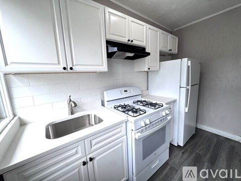 A kitchen with white cabinets and appliances.