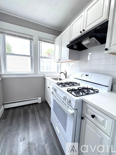 A kitchen with a white stove and cabinets.