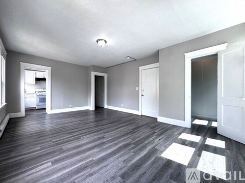 A spacious room with grey flooring and white walls.
