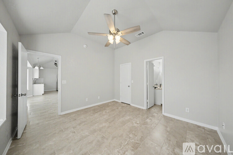 A spacious room with a ceiling fan and tiled flooring.