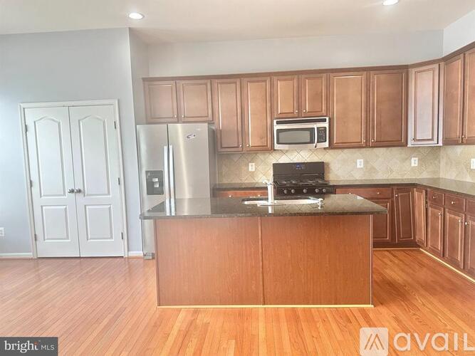A kitchen with wooden cabinets and a stainless steel refrigerator.