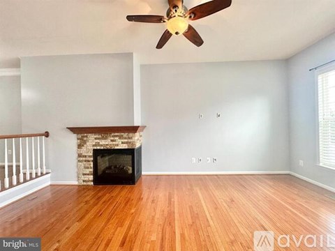 A living room with a fireplace and hardwood floors.