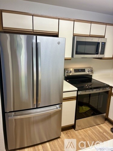 A stainless steel refrigerator and microwave in a kitchen.