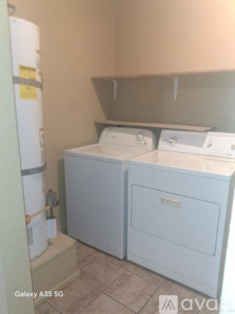 A small laundry room with a washer and dryer.