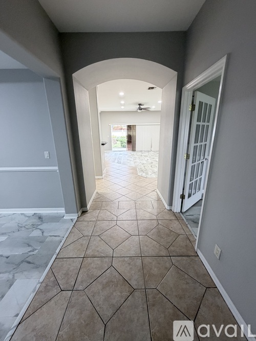 A hallway with a marble floor and a white door.