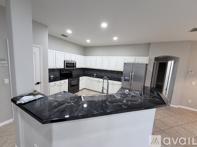 A kitchen with black countertops and white cabinets.