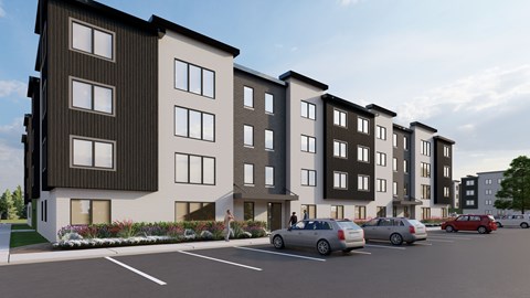 A row of modern apartment buildings with cars parked in front.