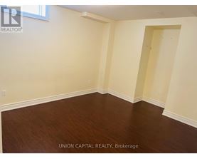 A room with wooden flooring and white walls.