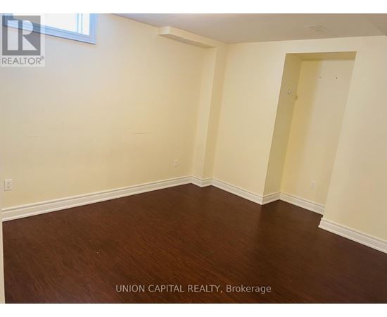 A room with wooden flooring and white walls.