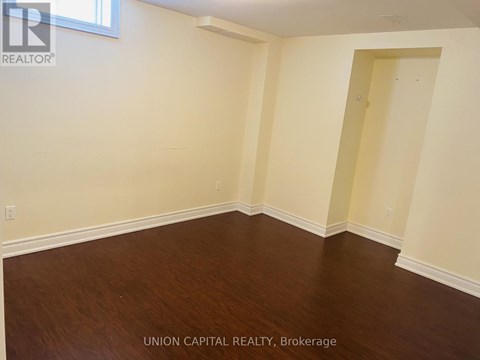 A room with wooden flooring and white walls.
