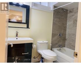 A bathroom with a toilet, sink, and tub.