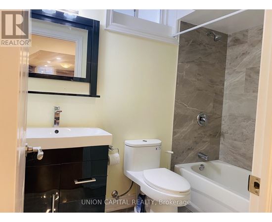 A bathroom with a toilet, sink, and tub.