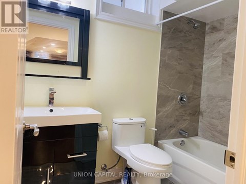 A bathroom with a toilet, sink, and tub.