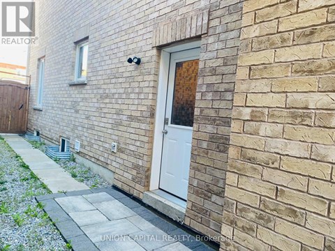 A brick building with a white door and a small window.