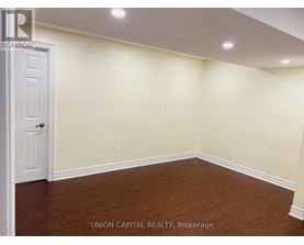 A room with a white door and wooden floor.