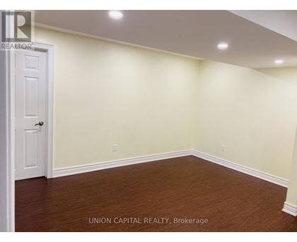 A room with a white door and wooden floor.