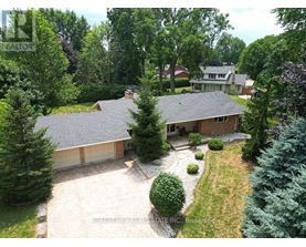 A house with a grey roof and a driveway in front of it.